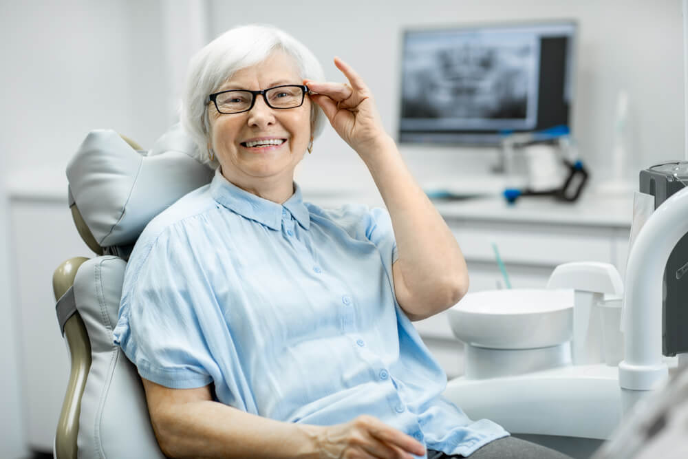 elderly woman smiling and receiving care under the canadian dental care plan